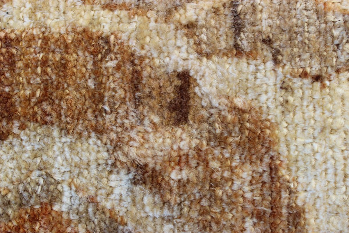 Close up of hand knotted wool pile in tan and rust tones